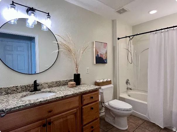 Bathroom featuring a wood-finish vanity with granite countertop, undermount sink, and matte black faucet