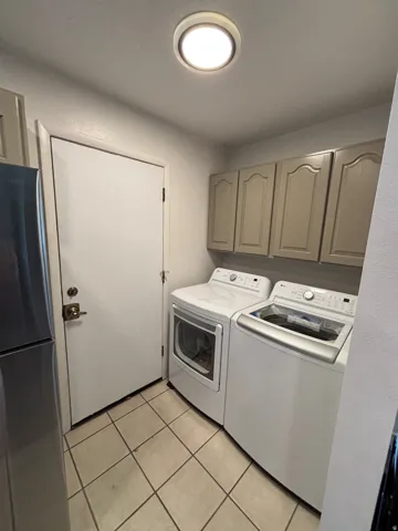 Utility area featuring a ceramic tile floor, recessed ceiling light, and built-in upper cabinetry