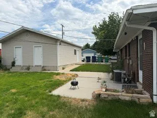 Two-story auxiliary structure with neutral vinyl siding and two exterior entrances
