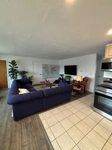 Open-concept living area featuring wood-finish flooring, light-colored walls, and recessed lighting