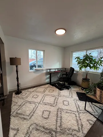 Room featuring dark wood-finish flooring and white walls