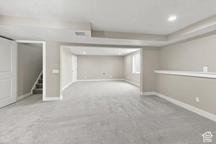 Spacious carpeted room featuring recessed lighting and a window with blinds