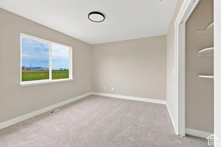 Spacious interior featuring neutral wall tones, plush carpeting, and crisp white trim