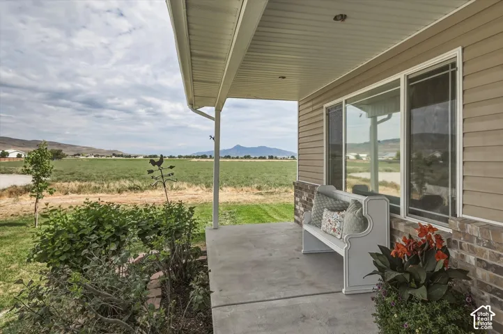 Covered front porch with concrete slab, flanked by a brick veneer base and horizontal siding