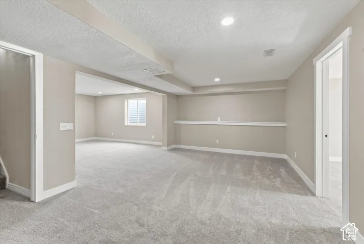 Spacious lower level featuring light gray carpeting, recessed lighting, neutral wall tones, and white trim
