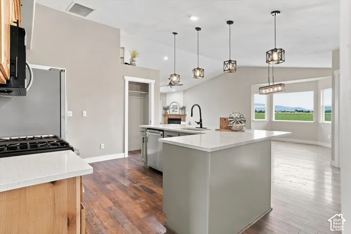 Kitchen featuring a center island with a white solid surface countertop and undermount sink with a black gooseneck faucet