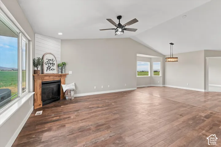 Spacious interior featuring wood-finish flooring, vaulted ceilings, and a fireplace with a shiplap accent wall