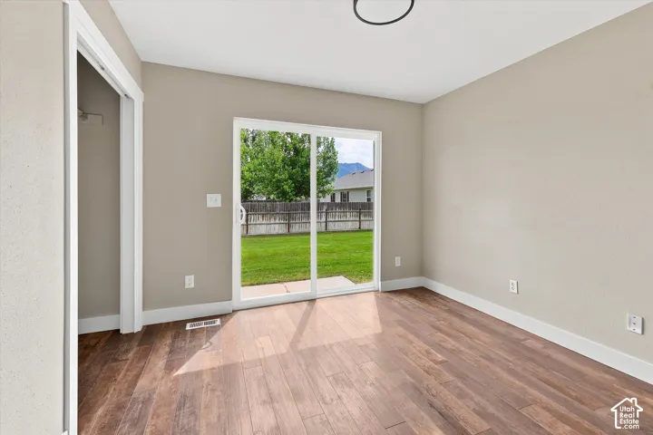 Room featuring wood-finish flooring, neutral wall paint, and white baseboards