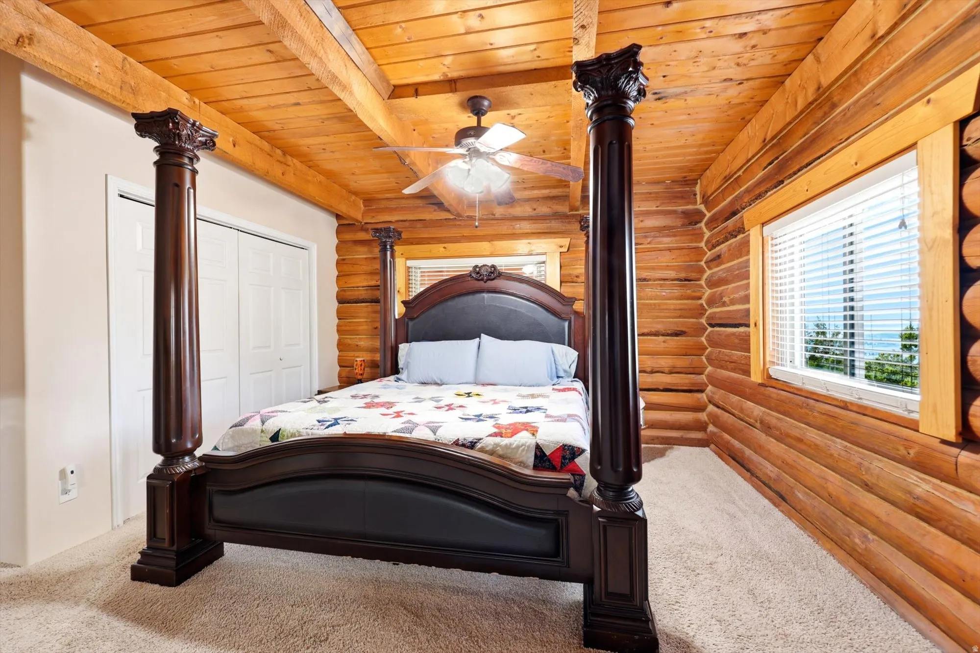 Primary ensuite with wood-paneled ceiling with exposed beams and a ceiling fan