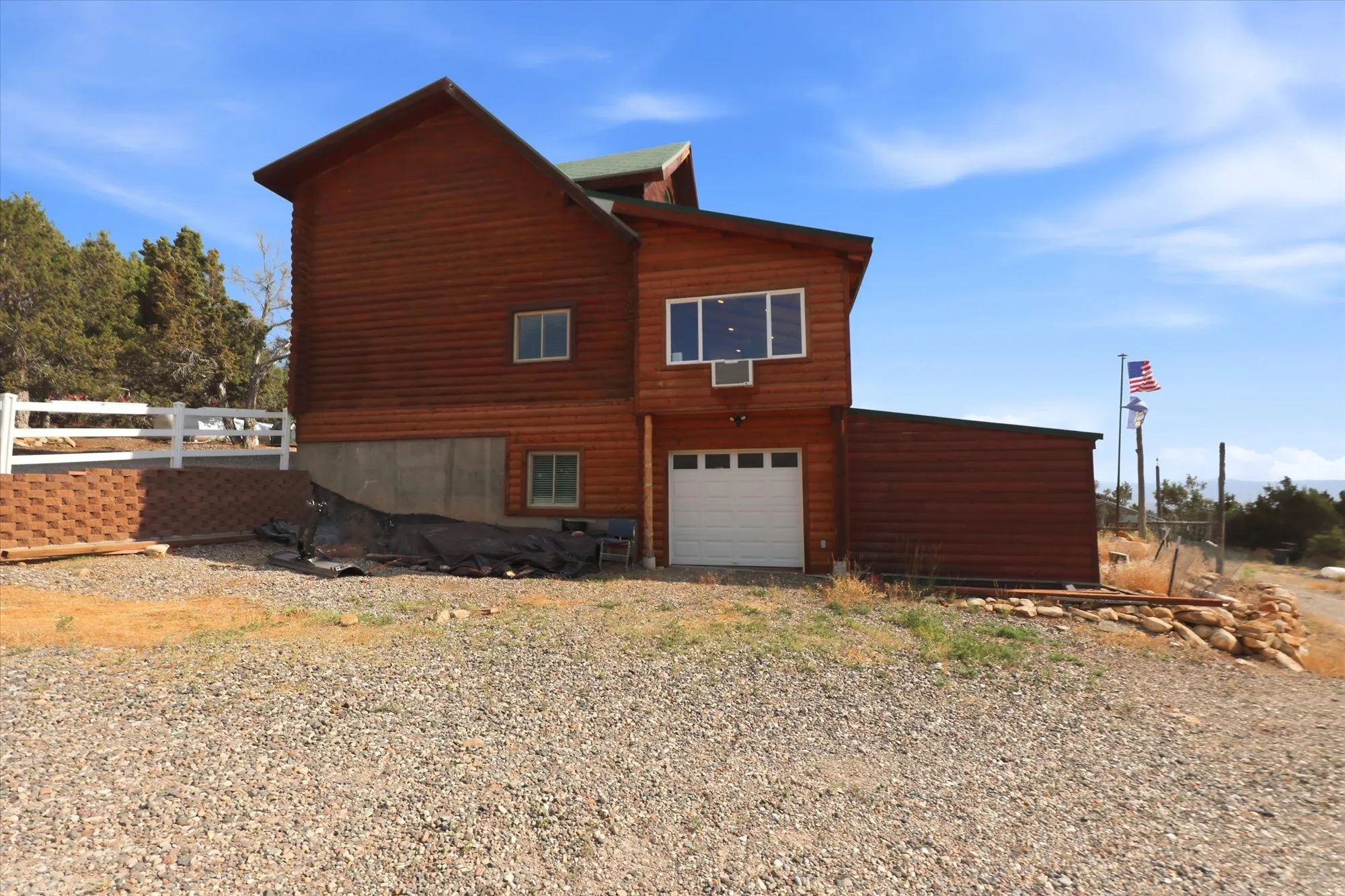 Attached garage and white vinyl fence