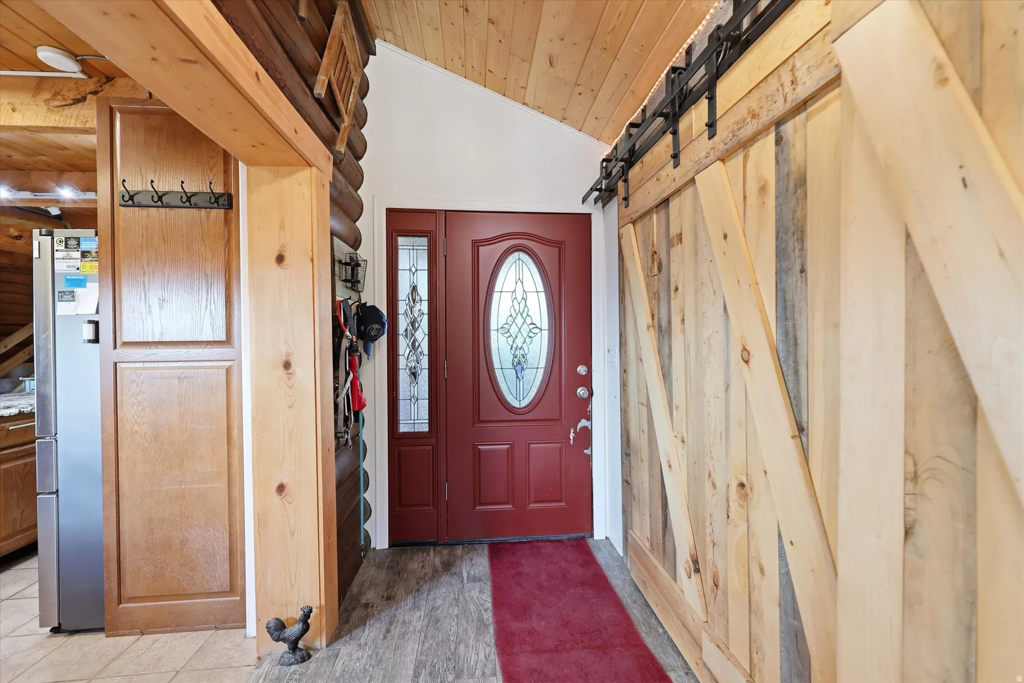Entryway featuring a red front door with decorative oval glass insert and sidelights