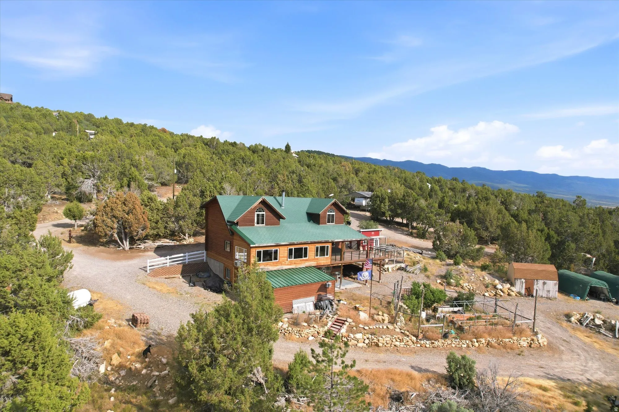 Arial view of the home showing the green metal roof and enclosed garden area