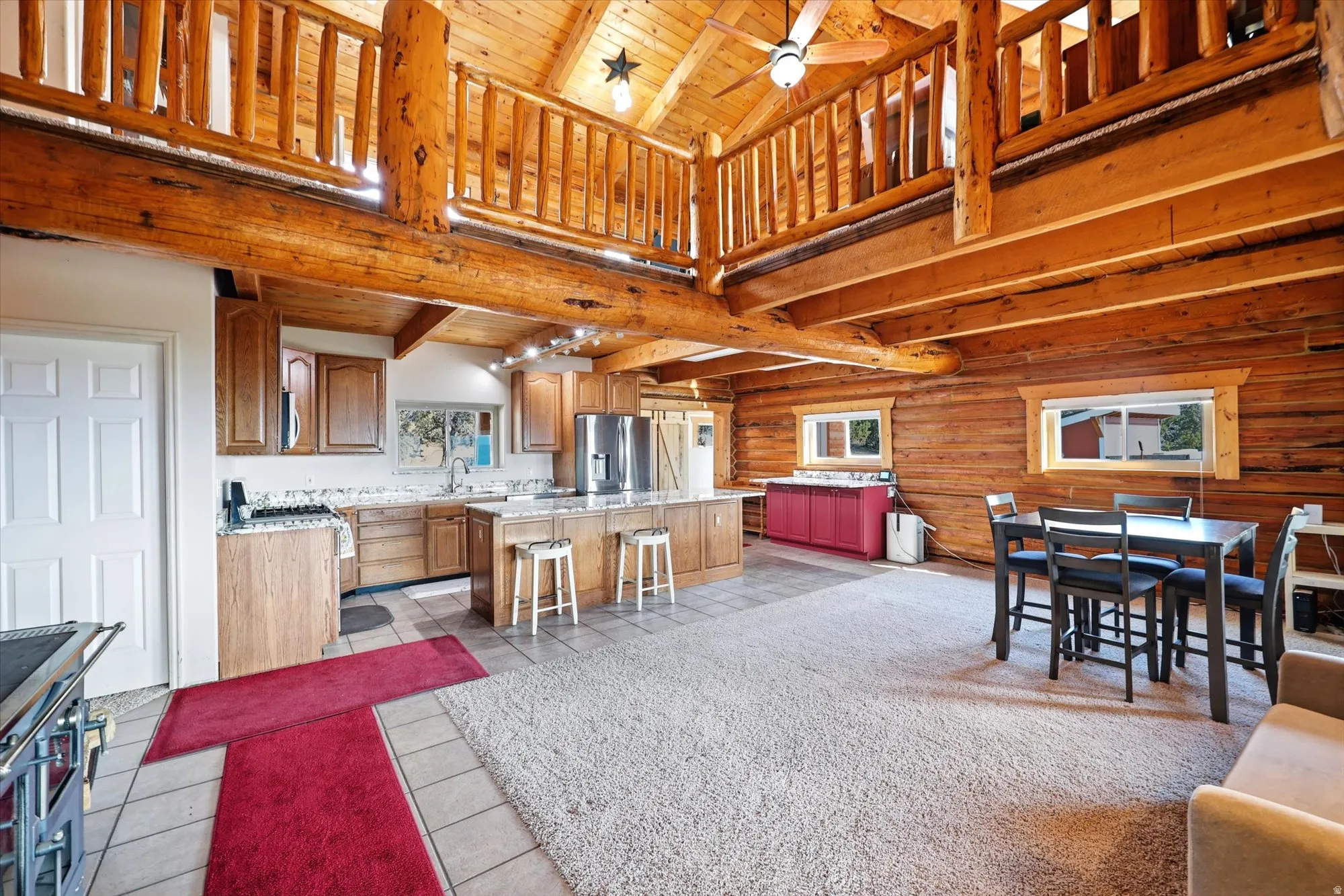 loft with wood railing white door leads to laundry/utility room