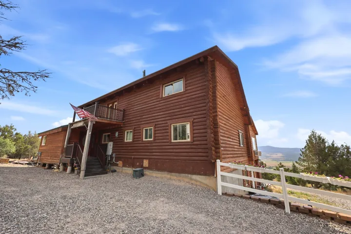 Log exterior featuring a second-story balcony