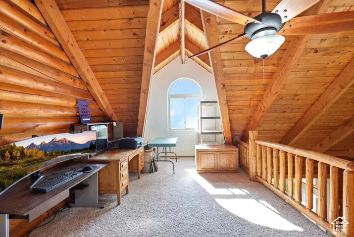 Loft space featuring extensive wood-finish walls and ceilings, a semi-circular window, and a wood baluster railing