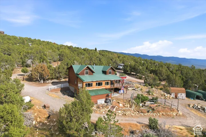 Arial view of the home showing the green metal roof and enclosed garden area