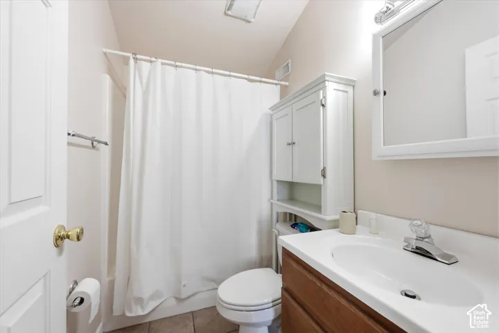 Bathroom featuring a wood-finish vanity with an integrated sink, white medicine cabinet, and a shower-tub combination