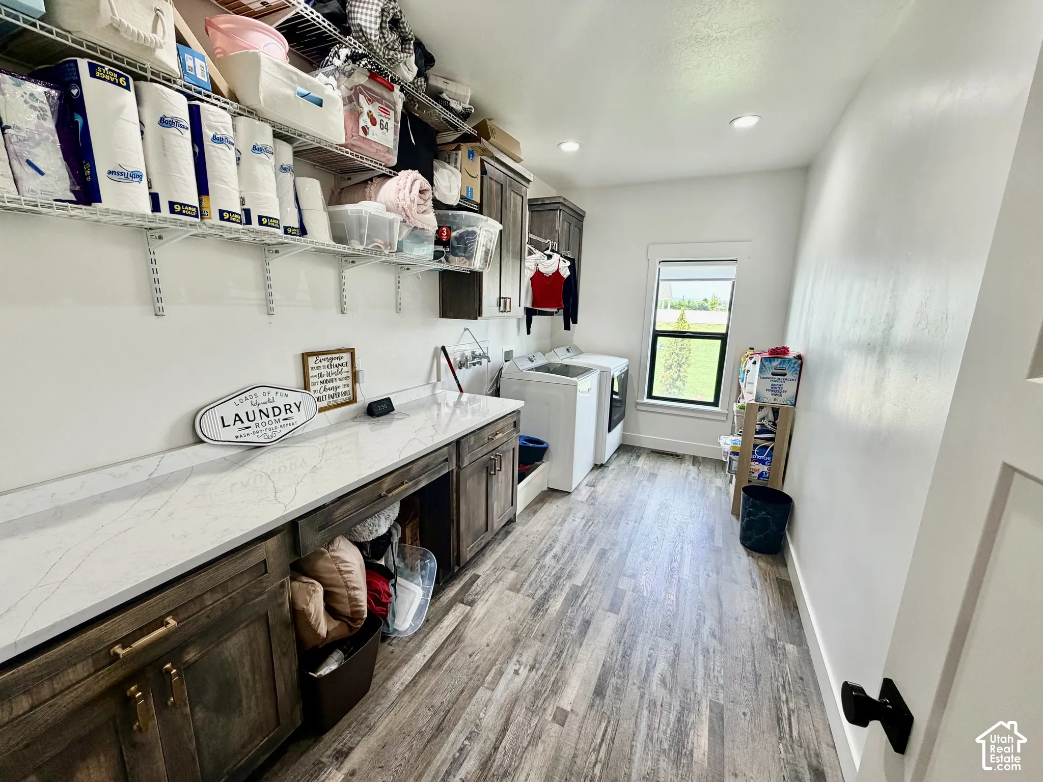 Utility room featuring wood-finish flooring and extensive white countertop space