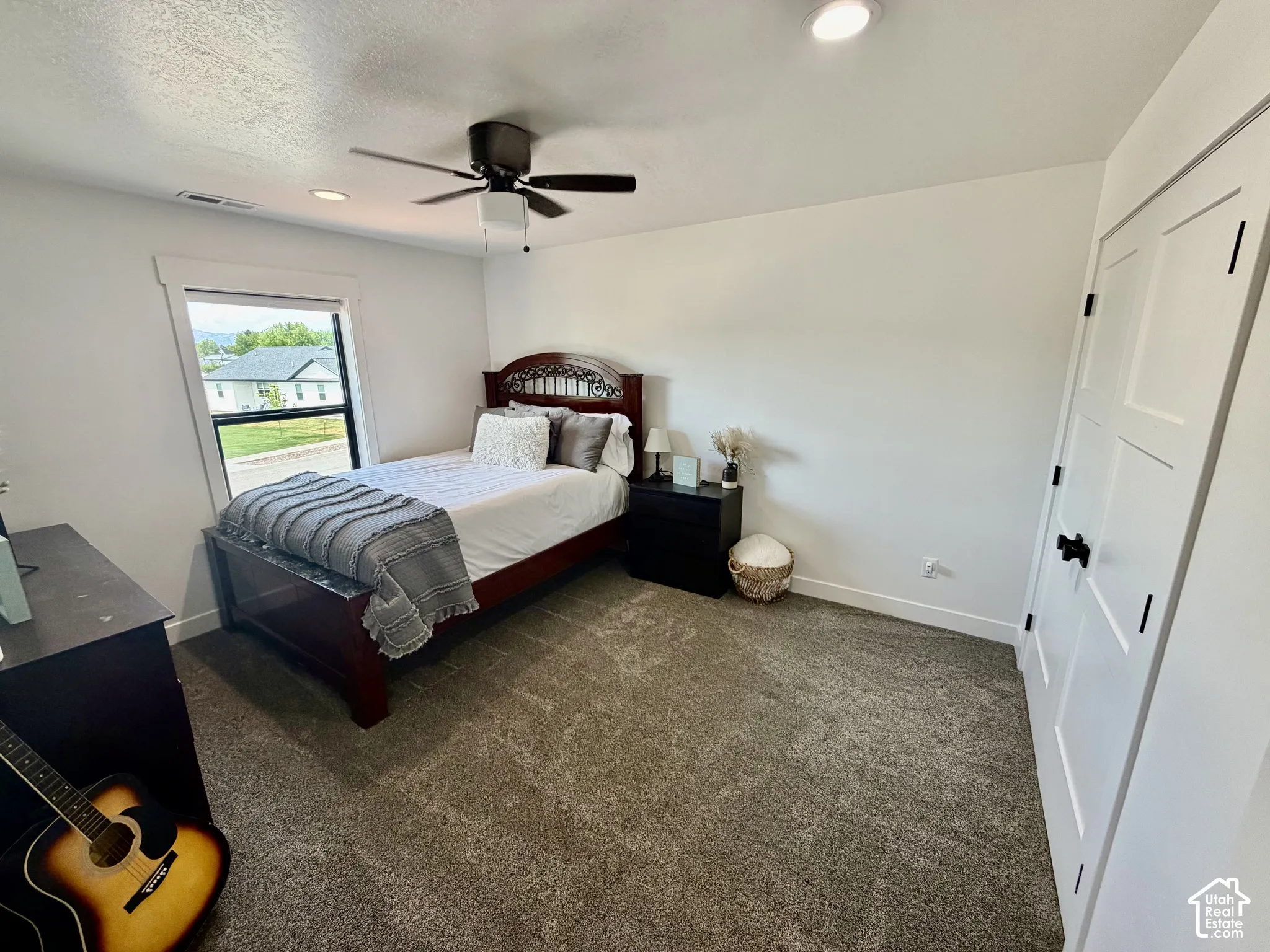 Carpeted room featuring a ceiling fan, recessed lighting, and a window with white trim