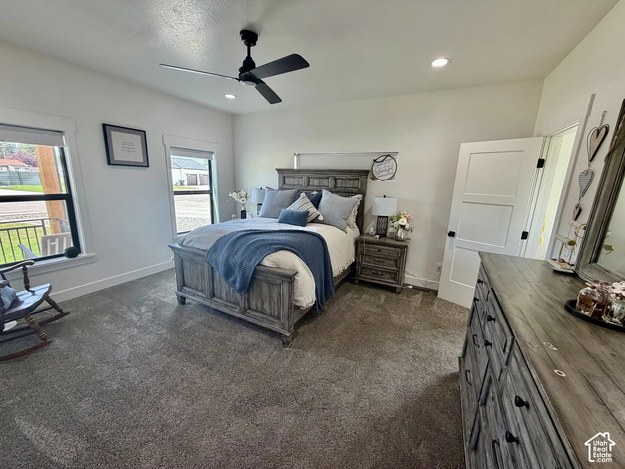 Spacious bedroom featuring neutral wall paint, recessed lighting, a ceiling fan, and two large windows