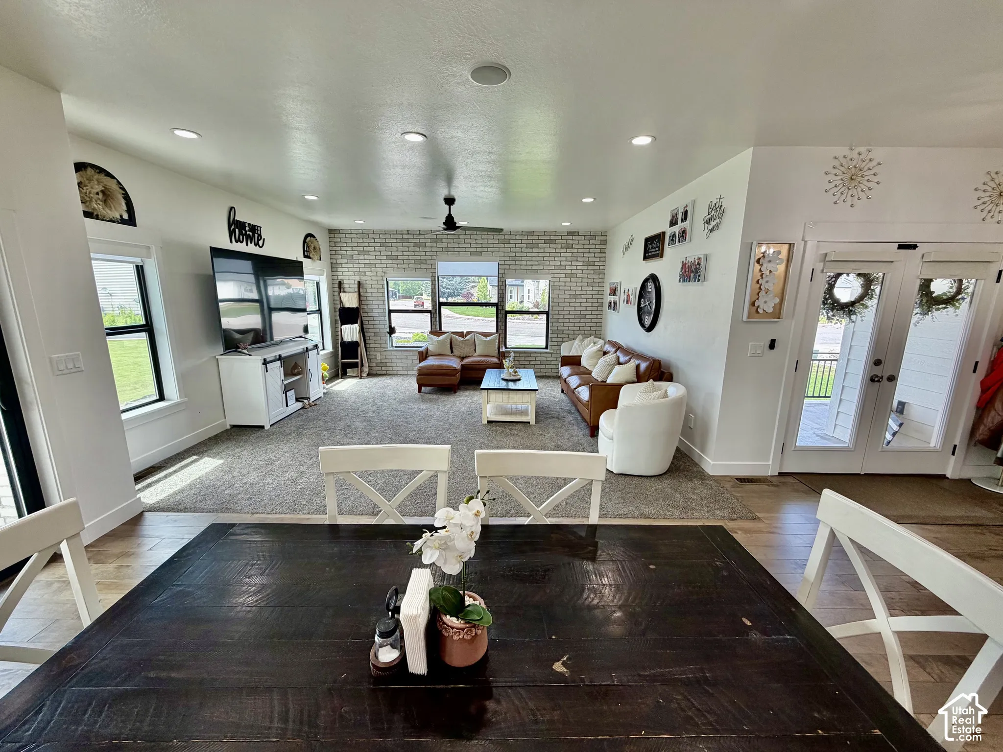 Open-concept living area with mixed flooring, featuring a large rug and wood-finish flooring