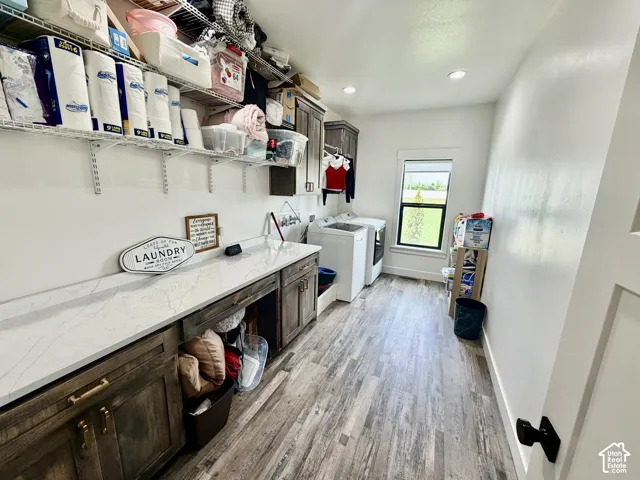 Utility room featuring wood-finish flooring and extensive white countertop space