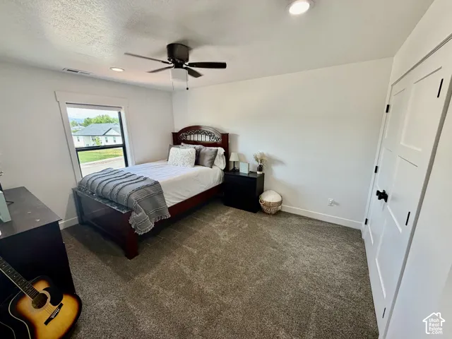 Carpeted room featuring a ceiling fan, recessed lighting, and a window with white trim