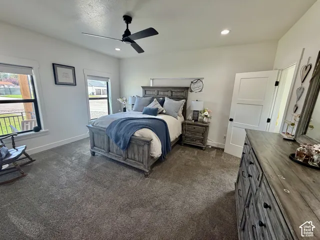 Spacious bedroom featuring neutral wall paint, recessed lighting, a ceiling fan, and two large windows