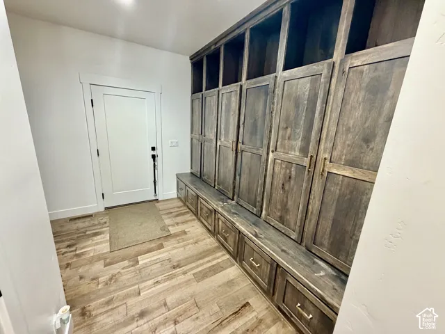 Built-in custom cabinetry featuring open shelving and closed storage, integrated bench seating, and wood-finish flooring