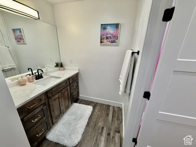 Vanity featuring a white countertop with an undermount sink, dark wood cabinetry, and matte black fixtures