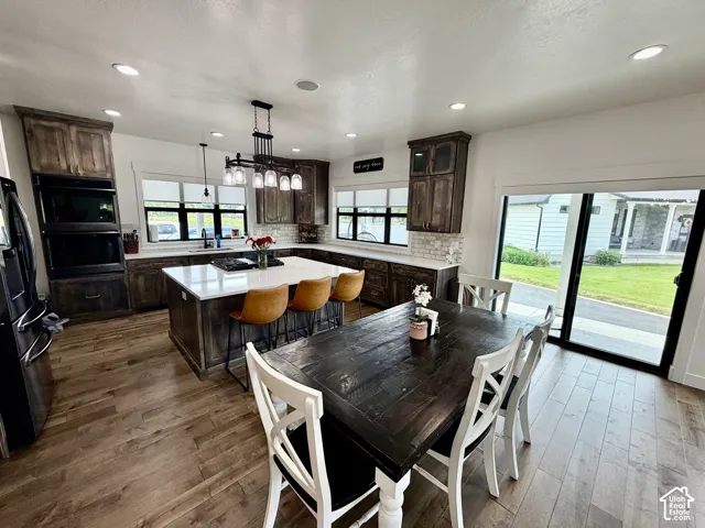 Open-concept kitchen and dining area featuring wood-finish flooring, recessed lighting, and a sliding glass door to the exterior