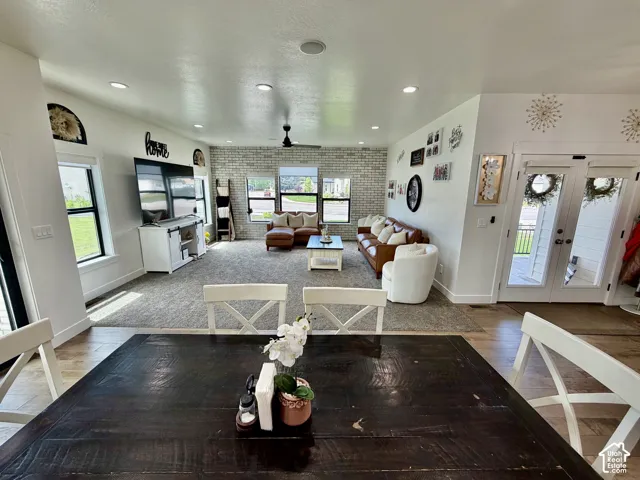 Open-concept living area with mixed flooring, featuring a large rug and wood-finish flooring