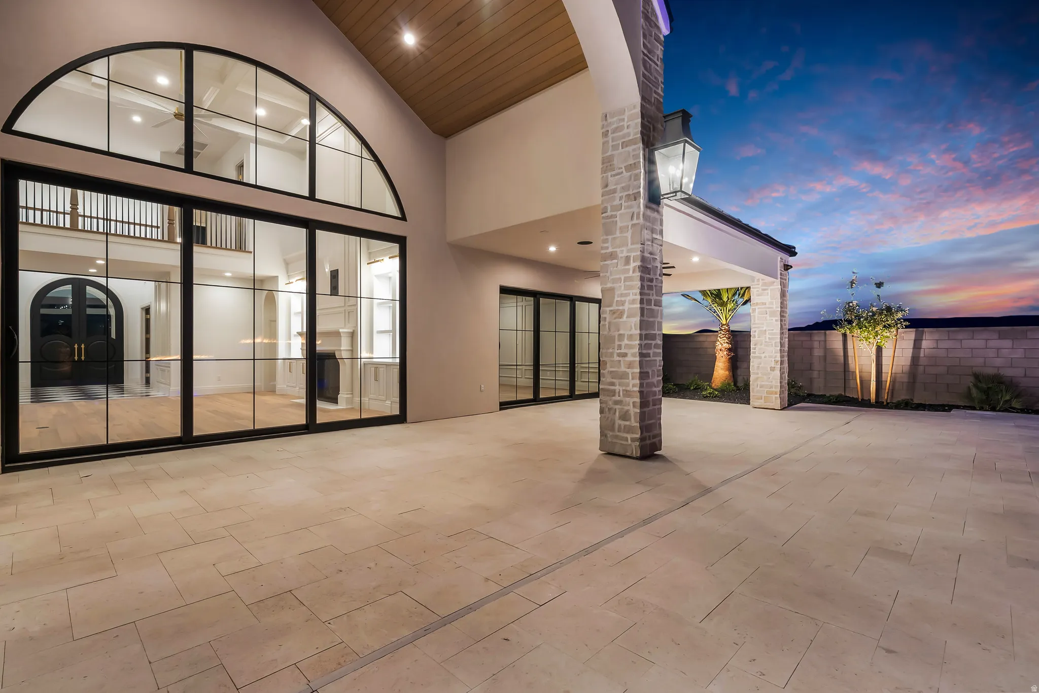 Expansive paver patio with a stone-clad column and integrated lighting