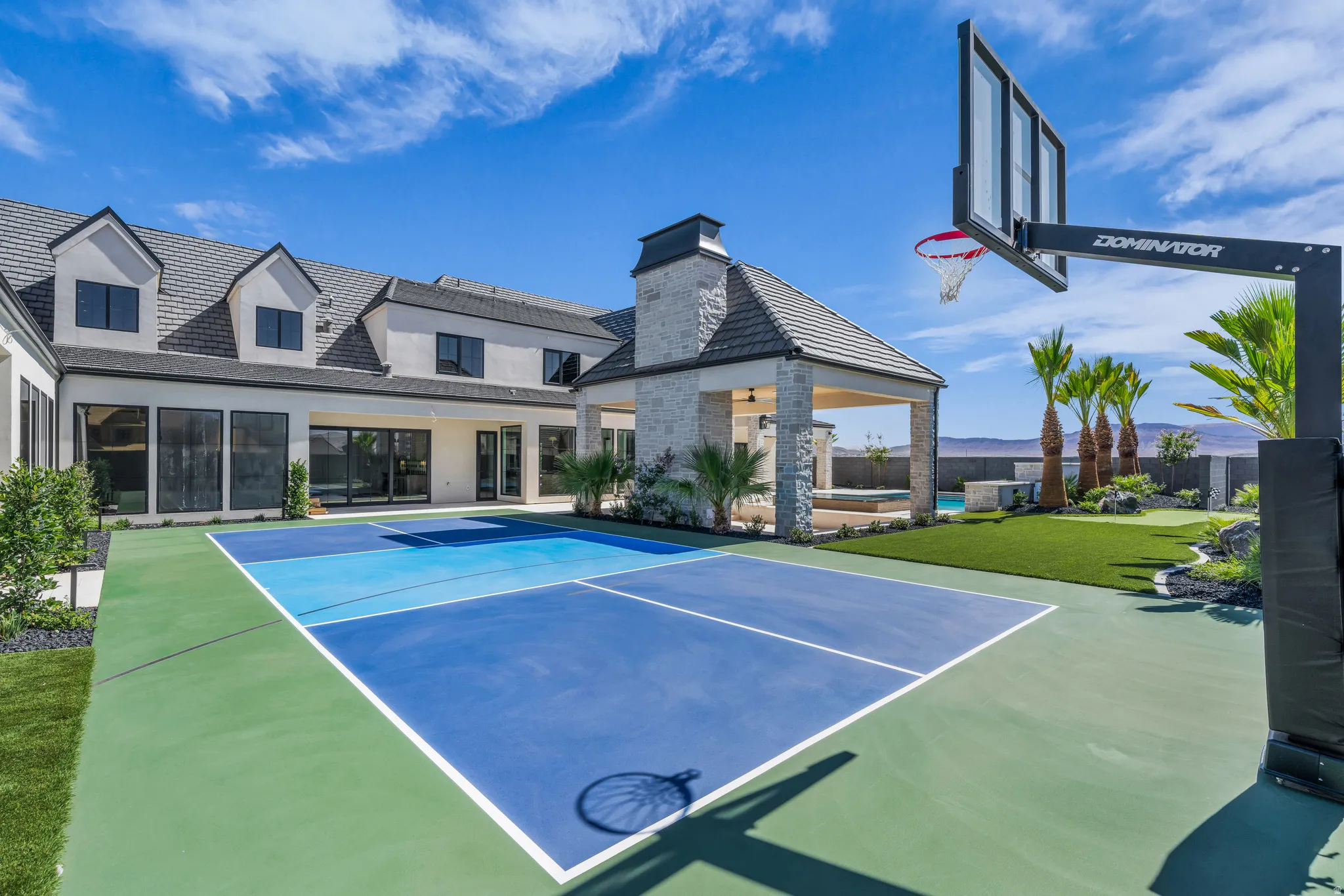 Multi-sport court featuring a basketball hoop and a green and blue surface