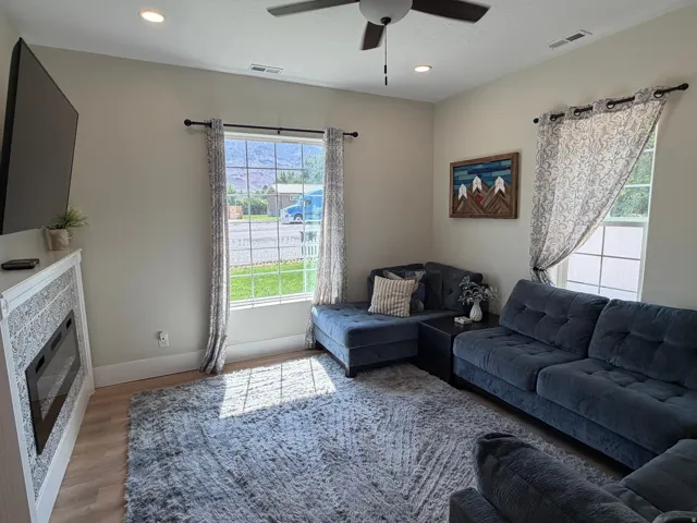 Living area featuring light wood-finish flooring and a built-in electric fireplace with decorative tile surround