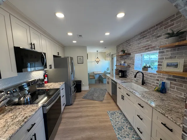 Contemporary kitchen featuring light wood-finish flooring and recessed lighting