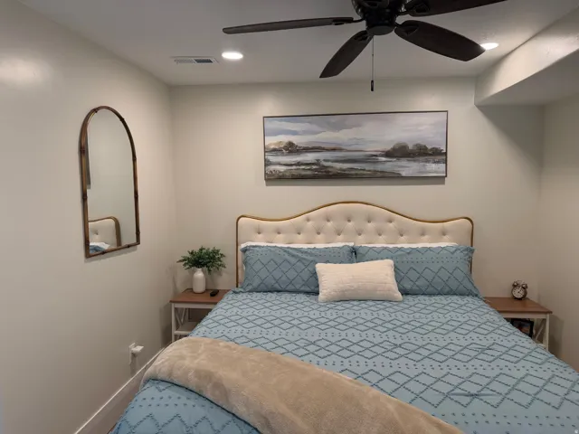 Bedroom featuring a tufted upholstered headboard, recessed lighting, and a ceiling fan