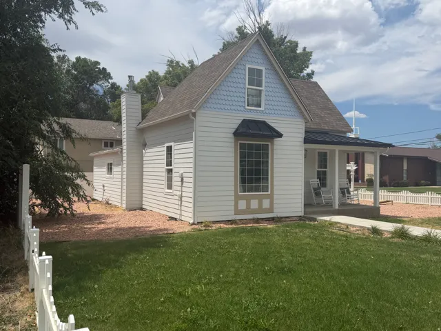 Charming architectural facade featuring white siding and light blue scalloped shingles