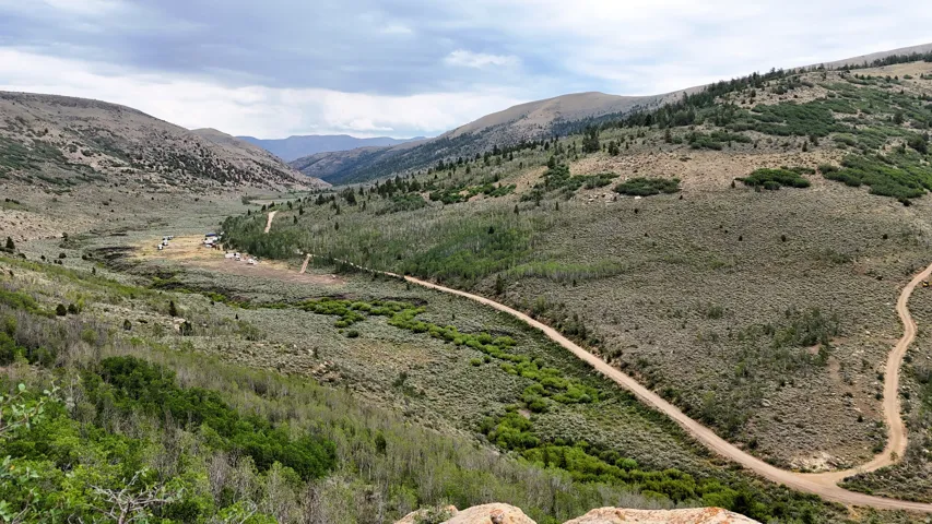 Expansive valley landscape with rolling hills and distant mountains