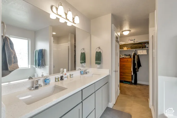 Double vanity with light gray cabinetry and white countertops, featuring integrated rectangular sinks and chrome fixtures