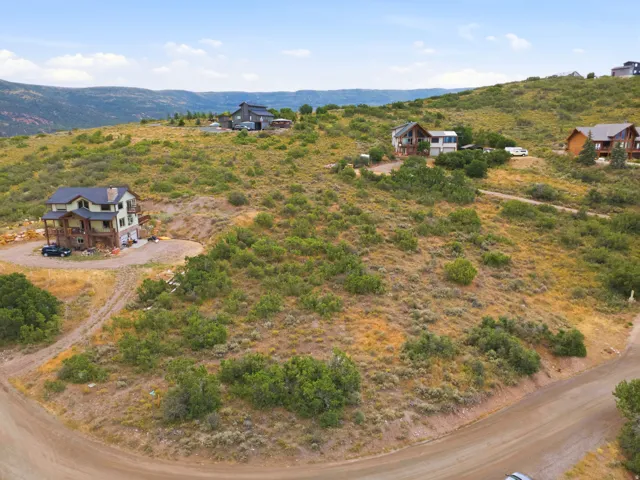 Rural landscape with scattered residential properties amidst rolling hills and natural vegetation