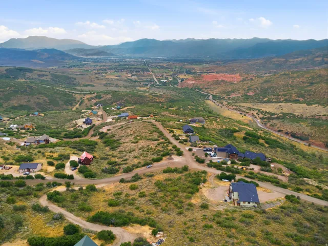 Expansive land featuring multiple residential properties with panoramic mountain and valley scenery