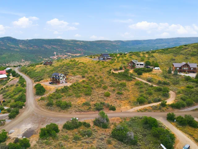 Mountainous terrain with established dirt roads and scattered residential structures