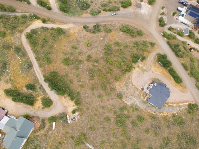 Expansive undeveloped lot featuring varied terrain and existing infrastructure