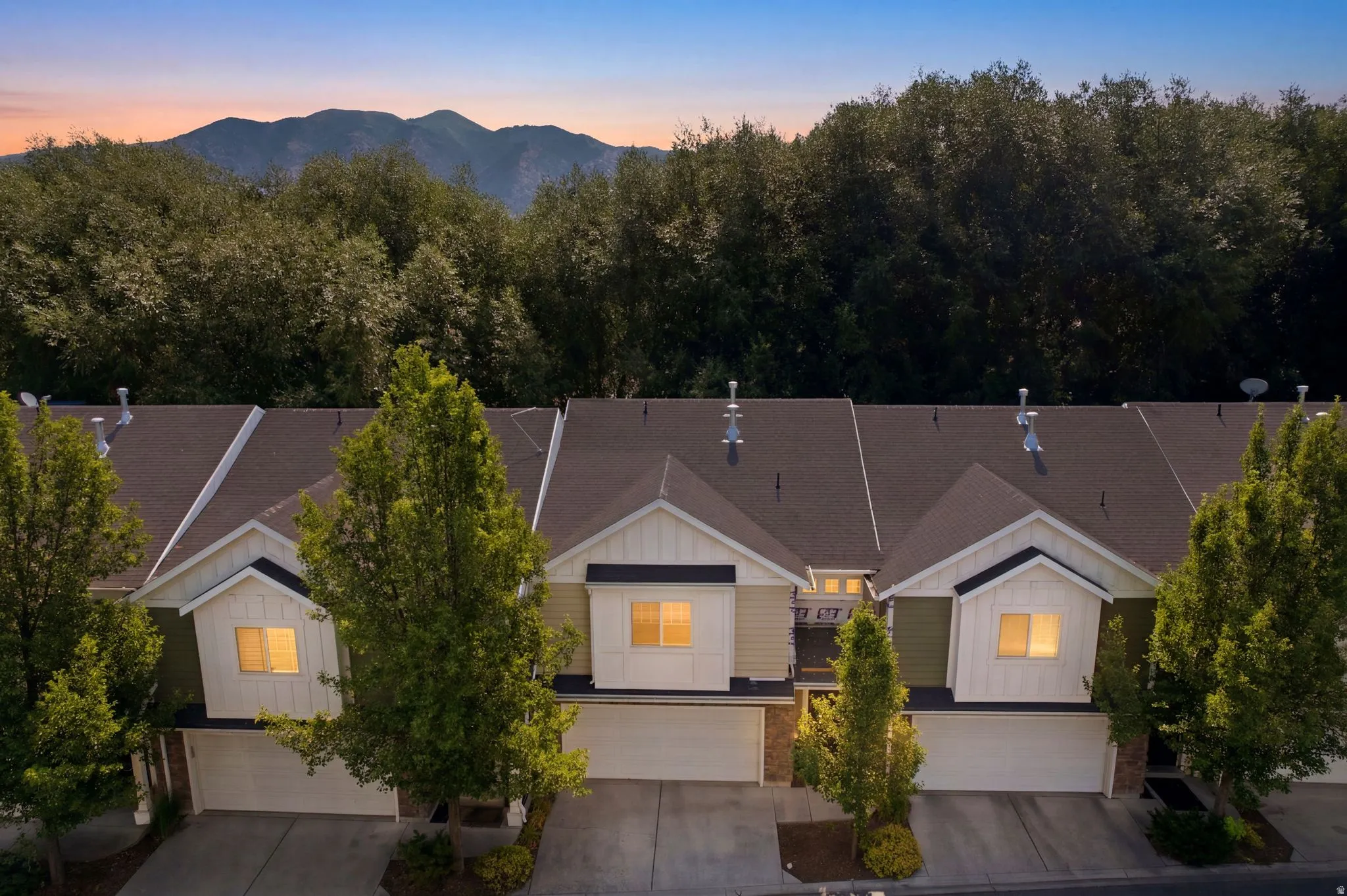 Townhome exterior featuring multi-toned siding, white trim accents, and attached garage doors