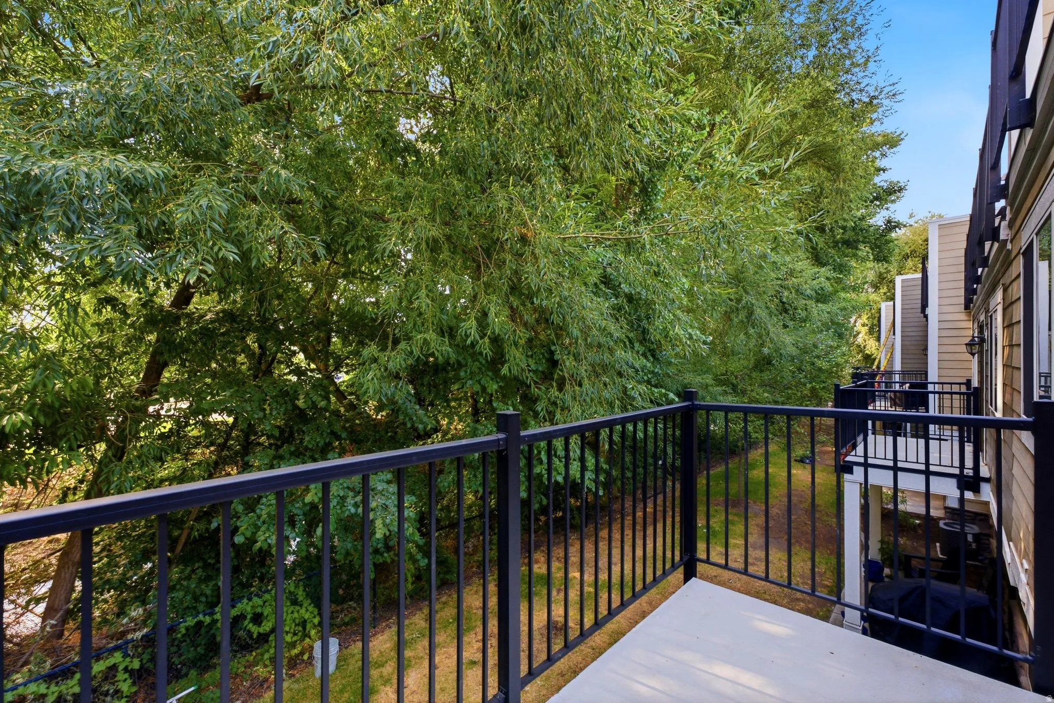 Private balcony featuring black metal railings and a concrete surface