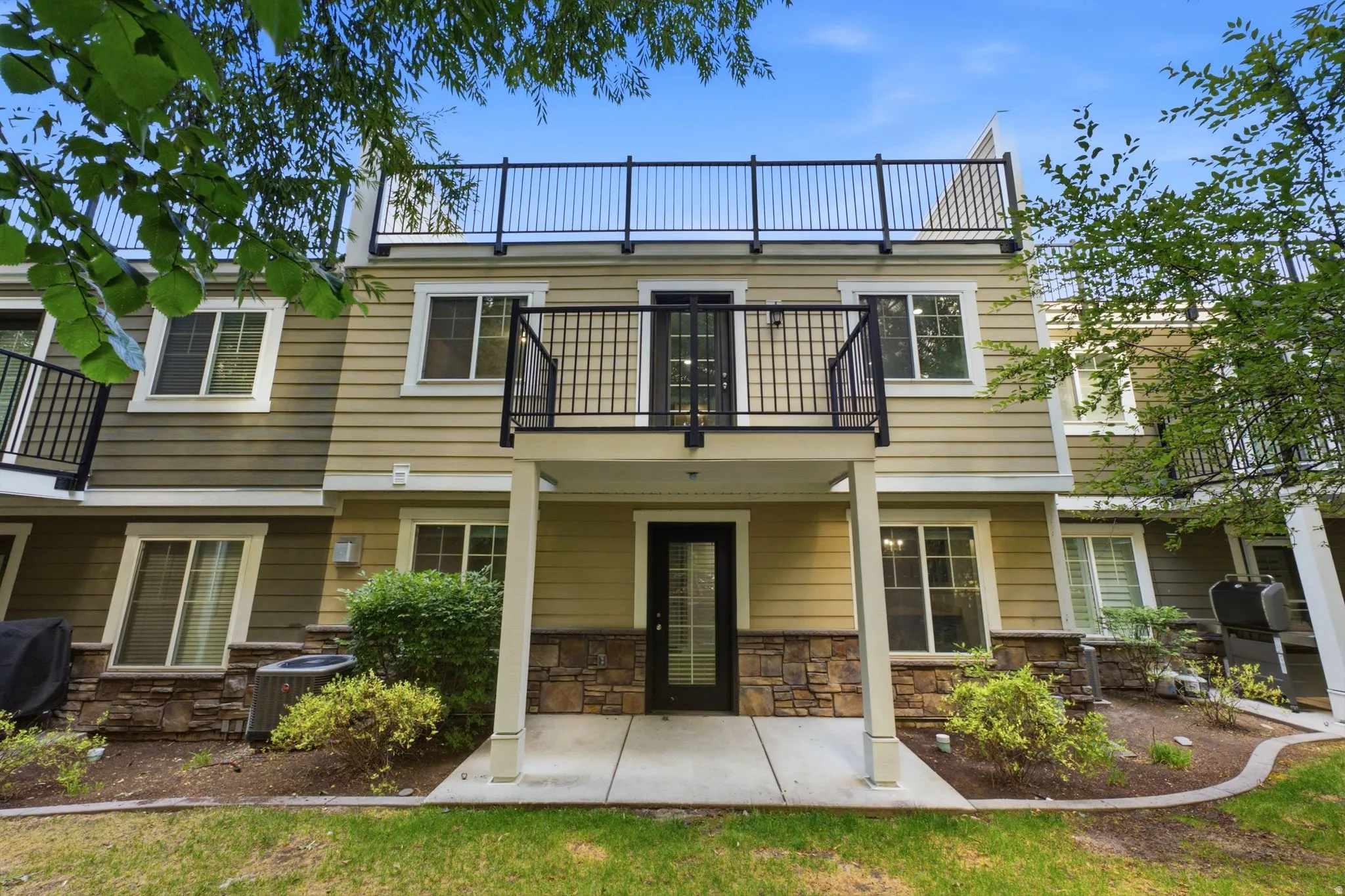 Multi-level exterior featuring siding and stone veneer accents