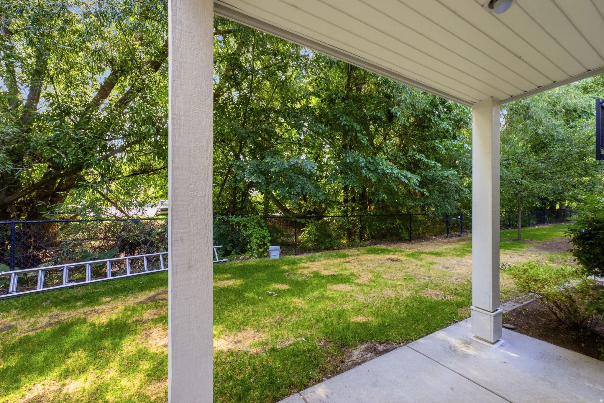 Covered patio featuring a concrete surface and white support columns
