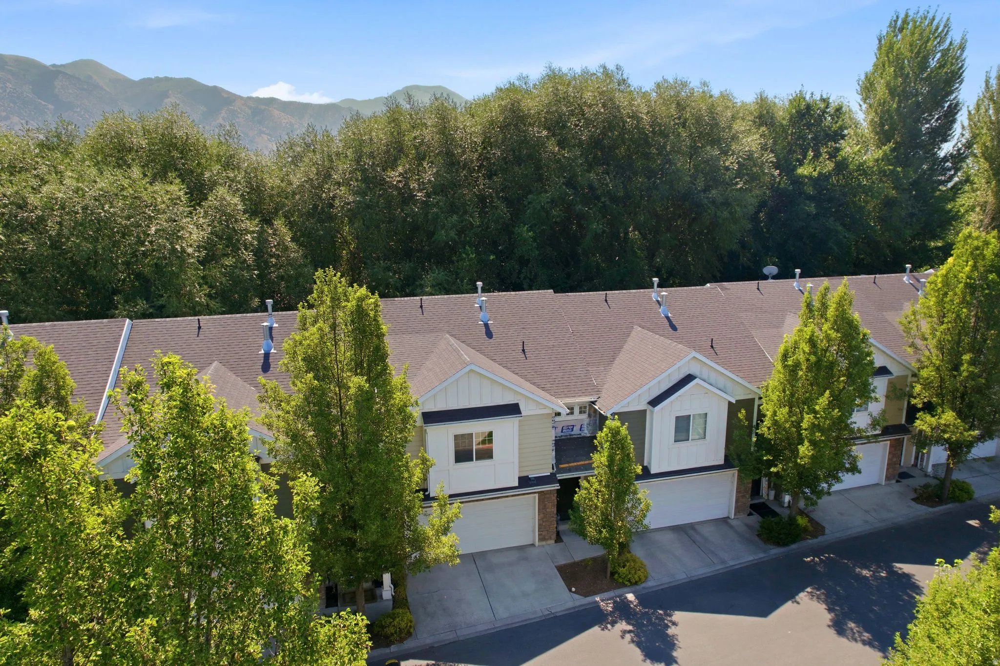 Row of townhomes featuring attached garages and individual driveways