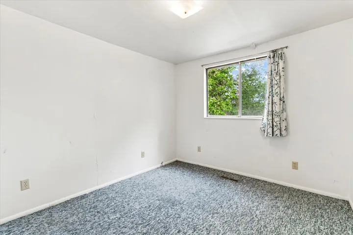 Room featuring a single window, overhead lighting, and wall-to-wall carpeting